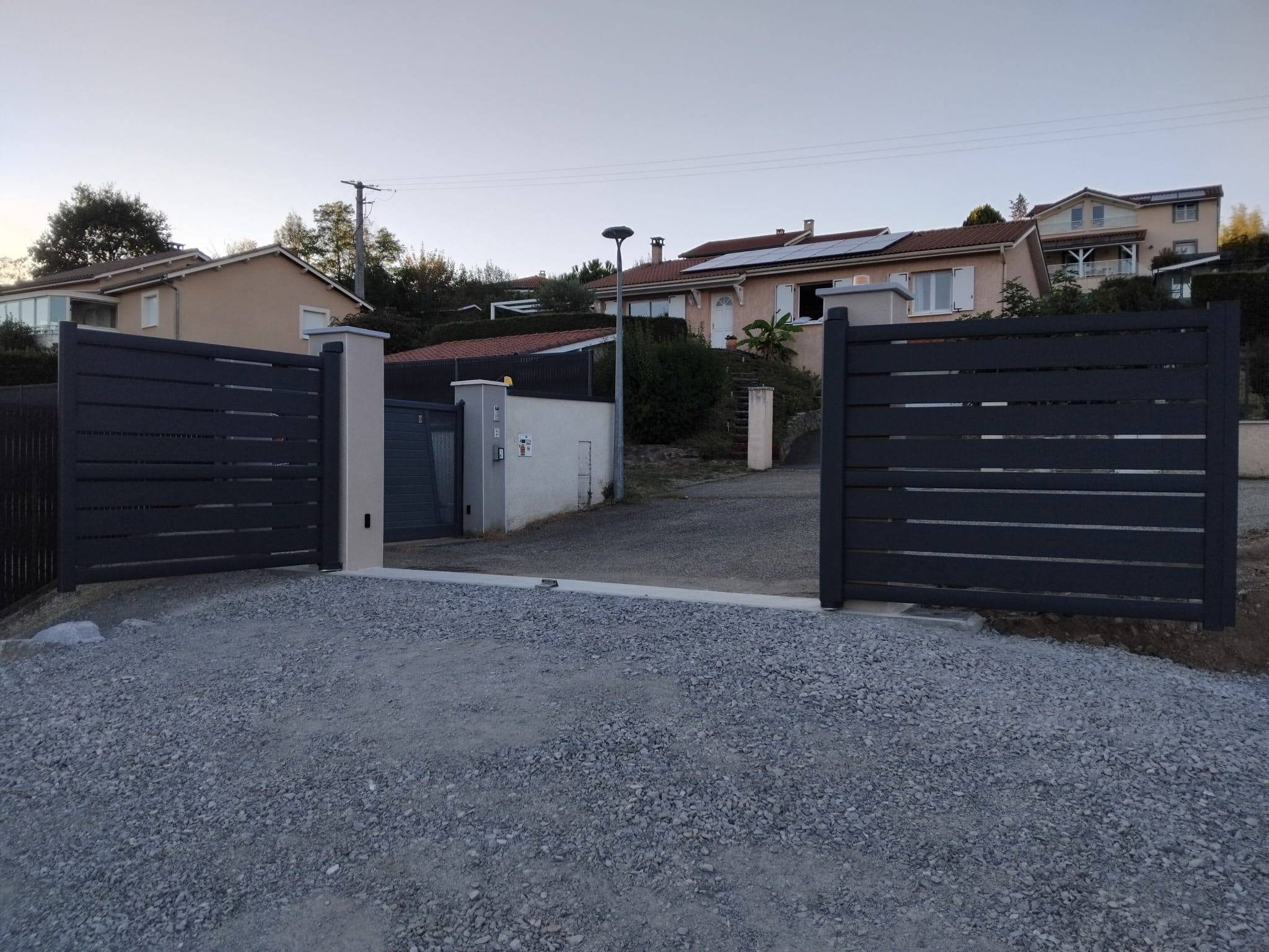 Portail motorisé ouvert, allée dégagée à Saint-Martin-en-Haut