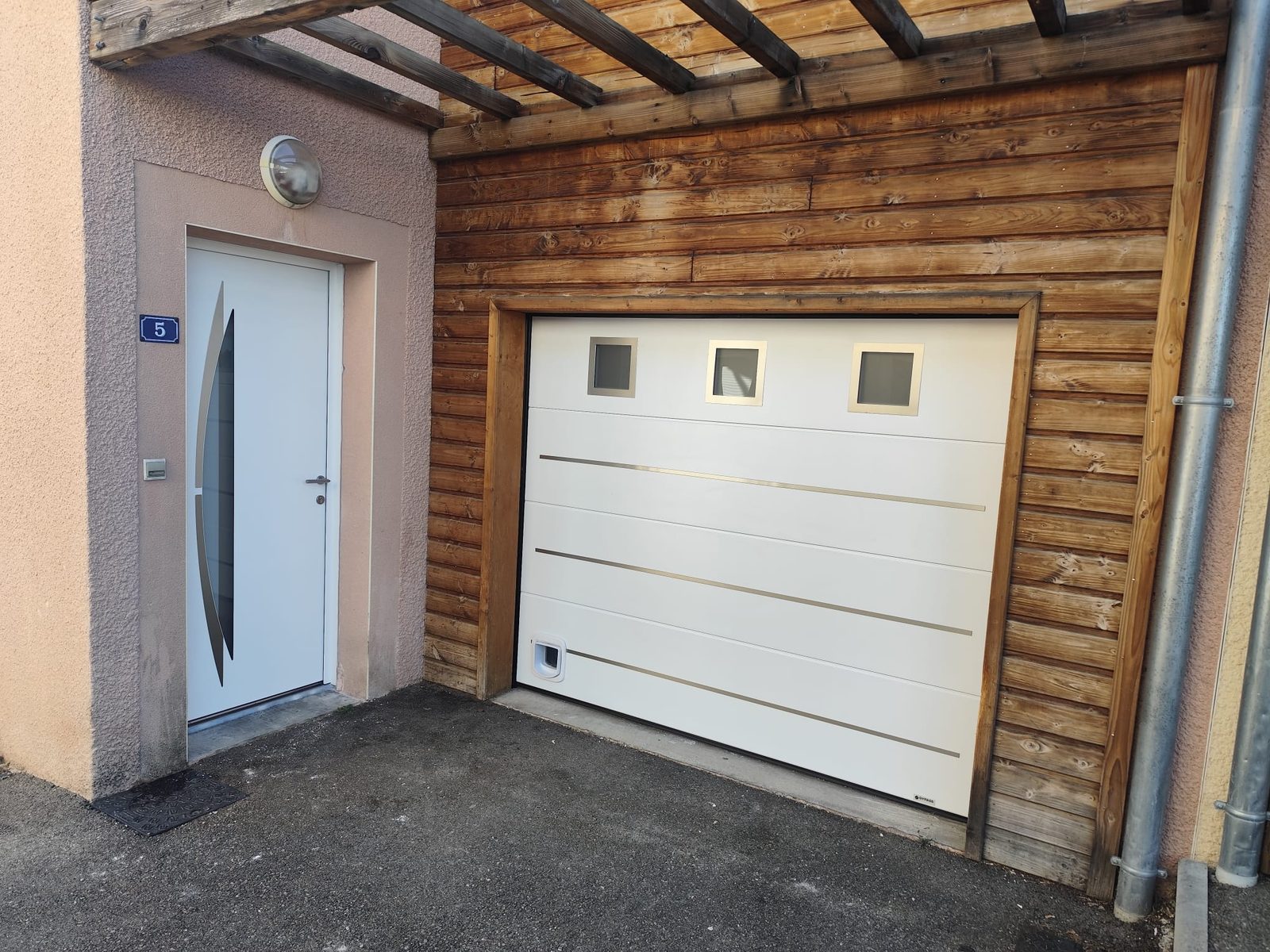 Façade rénovée avec porte d'entrée et porte de garage assorties à Thurins