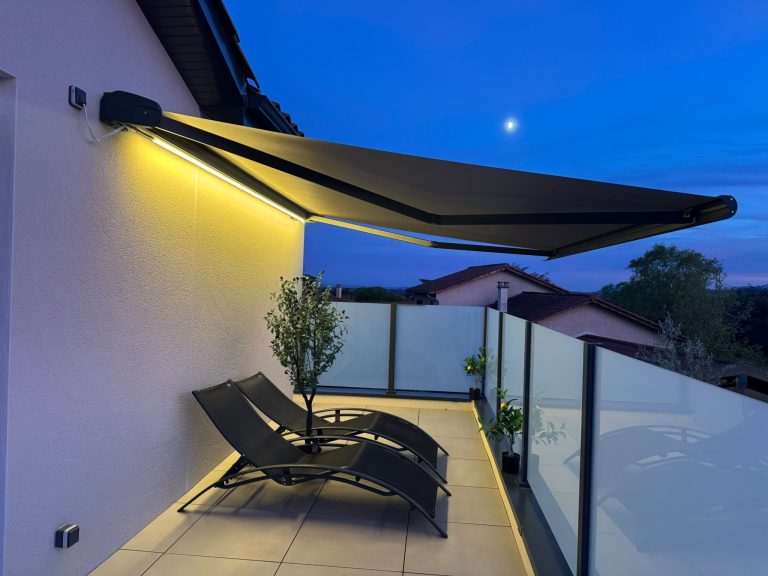 Store banne avec ruban LED intégré sur une terrasse à Brindas, vue de nuit